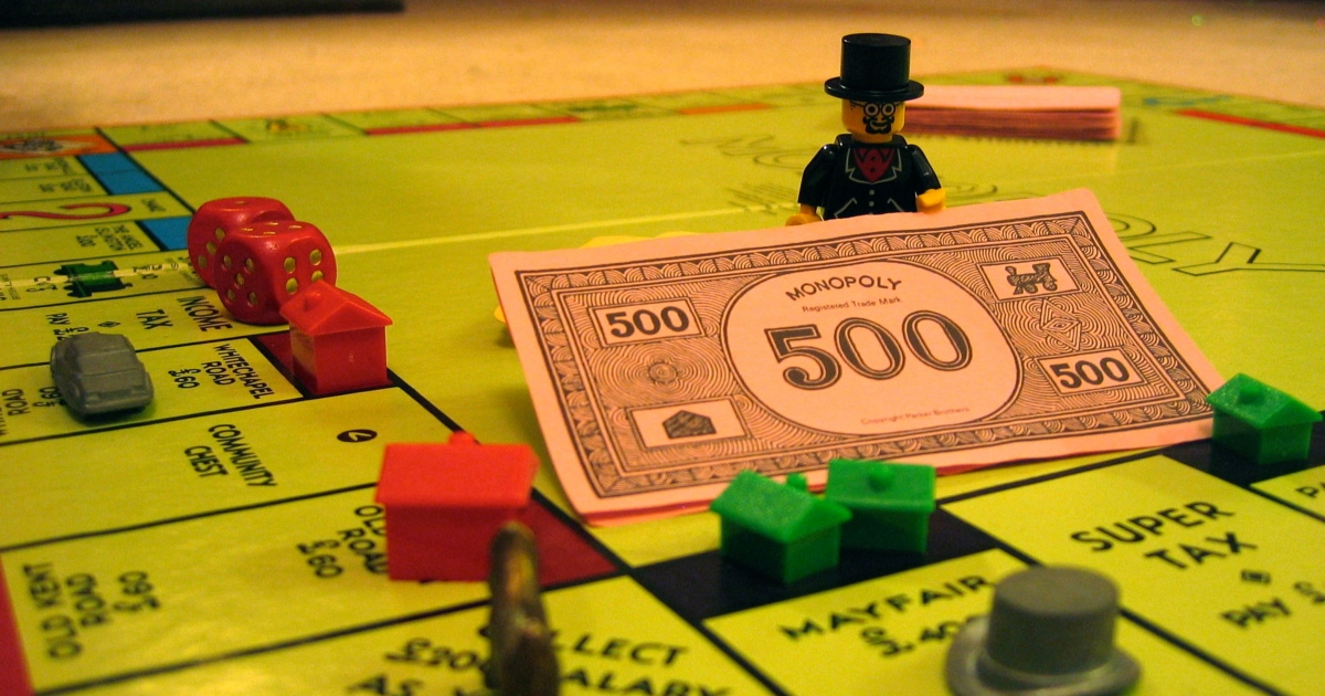 Monopoly board with $500 cash and various houses, hotels, and red die
