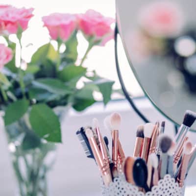 makeup brushes and flowers on a counter