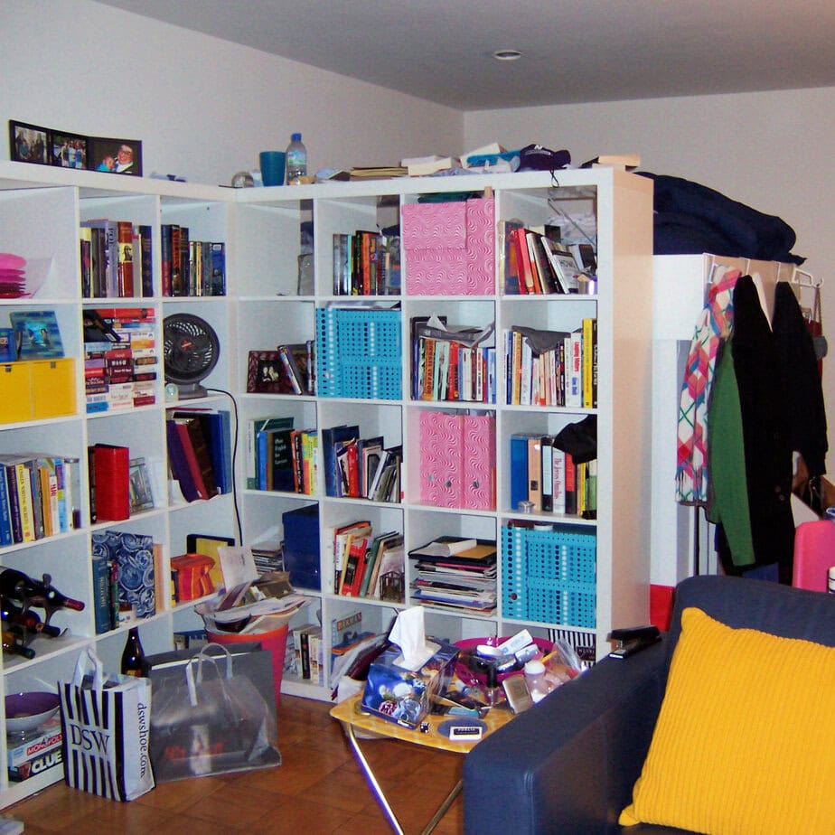 Kat's studio apartment after law school with bright pink, blue and yellow details to offset the darkness of the cave-like apartment