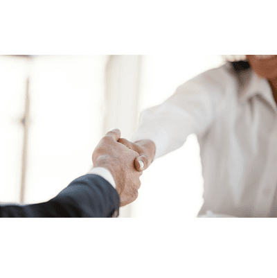 woman in white blouse shakes hands with man in a business suit