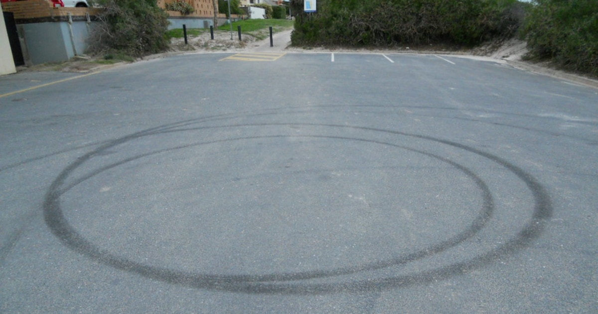 concrete of a parking lot with marks from where a car spun in circles