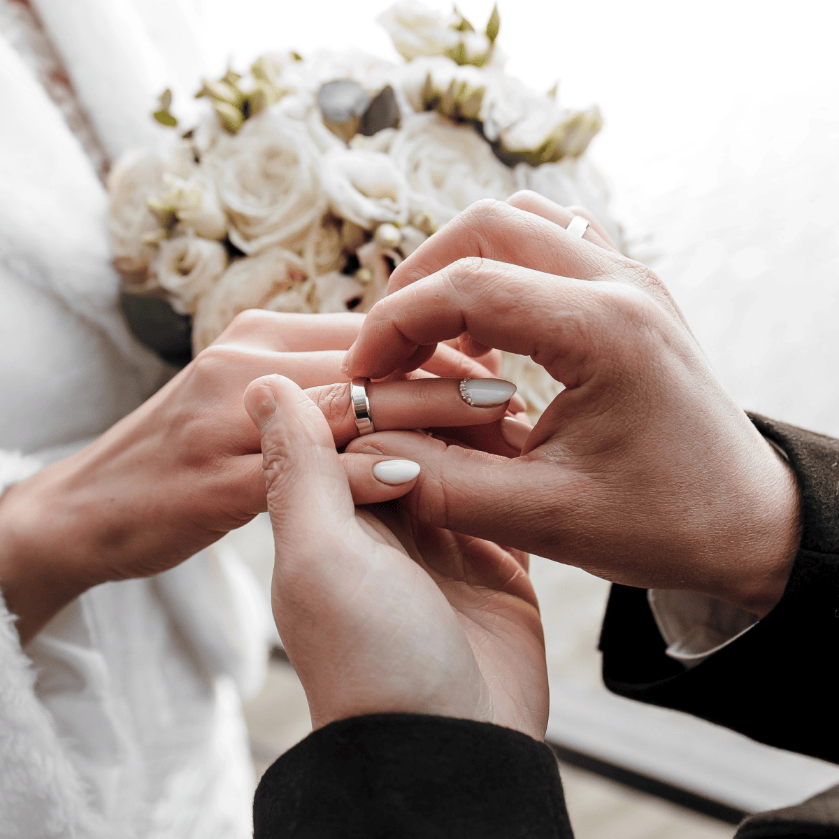 Alt: Man placing a wedding ring on a woman's finger during a wedding ceremony