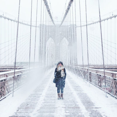 woman walking on Brooklyn Bridge in winter