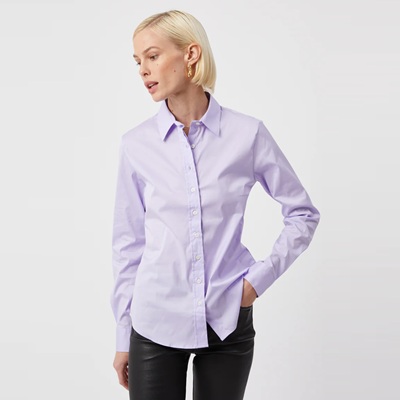 A woman wearing a lavender blouse and black leather pants