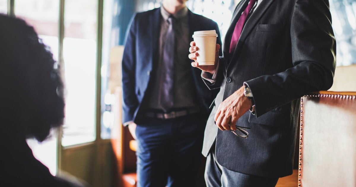 businessmen gossiping over coffee