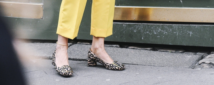 woman wears animal print pumps with bright yellow cropped pants