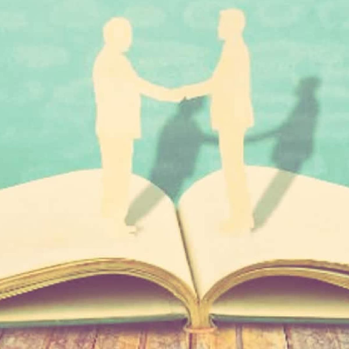 artistic rendering of two people shaking hands and possibly one is a woman building her book of business -- the figures look like cardboard cutouts sitting on top of an open book.