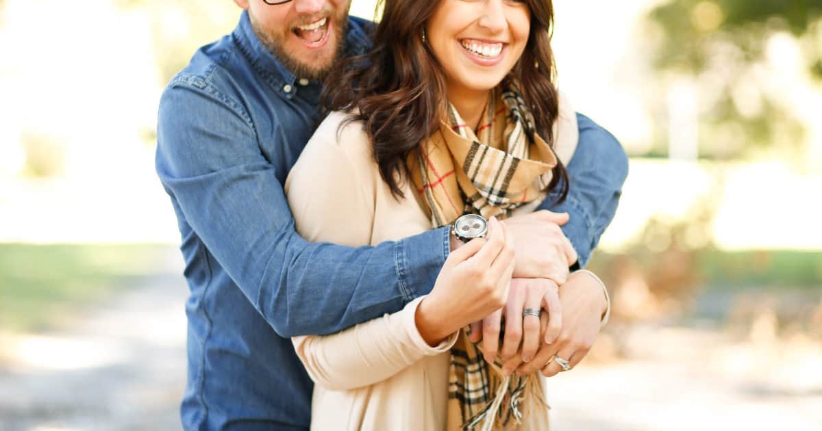 how to manage your money once you get married -- image of a couple hugging and laughing