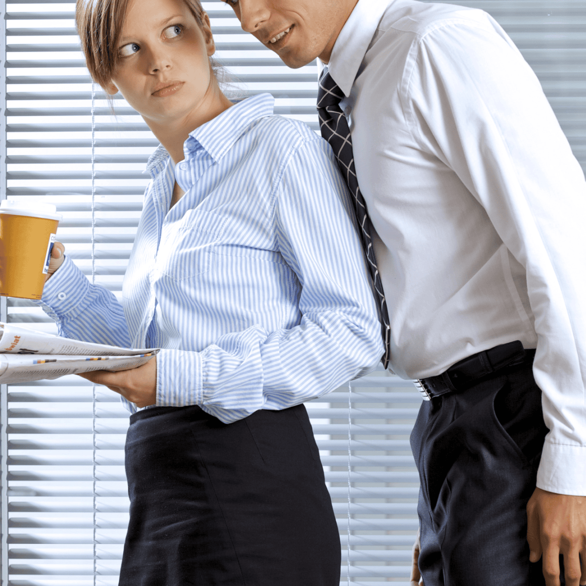 man in white shirt and tie is leaning uncomfortable close to a professional woman in a blue blouse and skirt; she is looking at him with a WTF expression and holding a coffee cup and piece of paper.