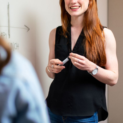 young woman wears sleeveless top and wonders - are there any rules around going sleeveless at the office in 2025?