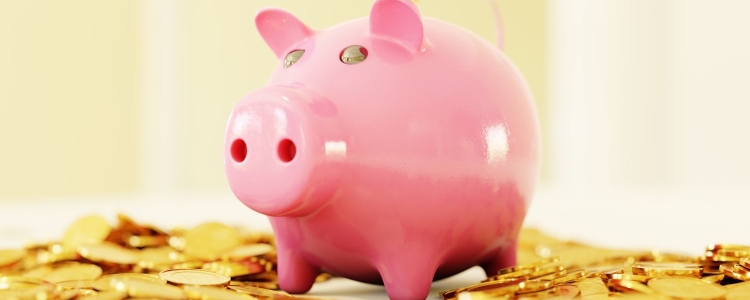 pink piggy bank sits on a pile of gold coins