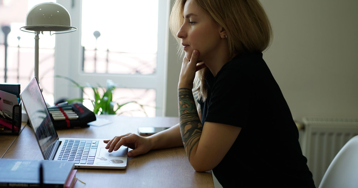 stock photo of young woman answering work email at home