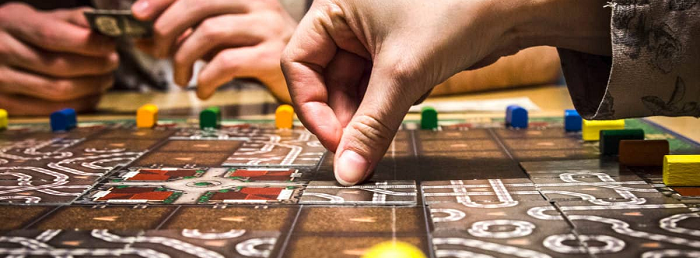 close up of board game; a hand is placing a piece on the board