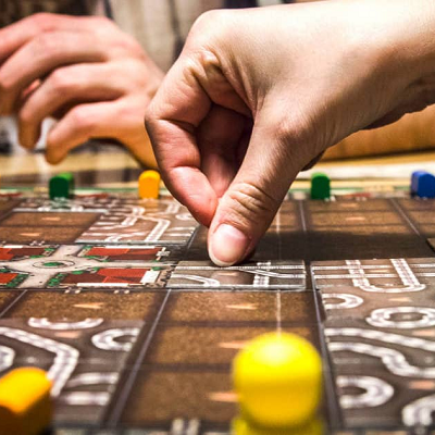 close up of board game; a hand is placing a piece on the board