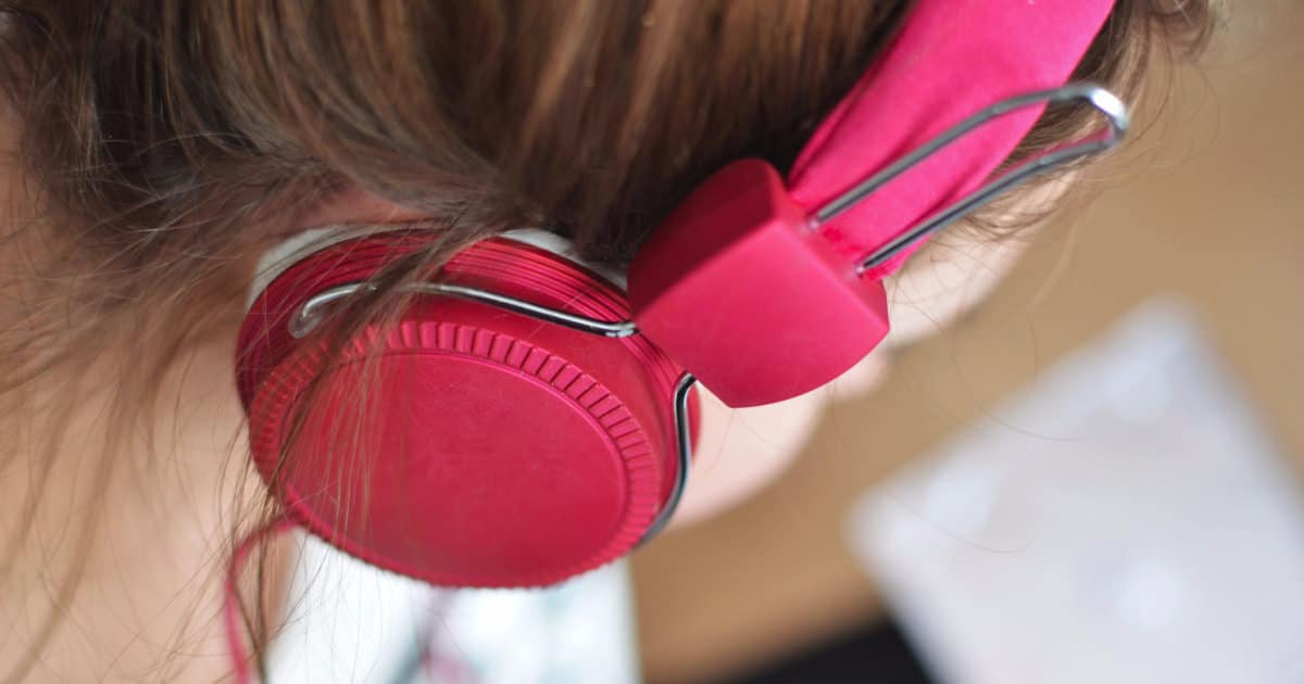 the best podcasts for professionals - picture of a woman with pink headphones