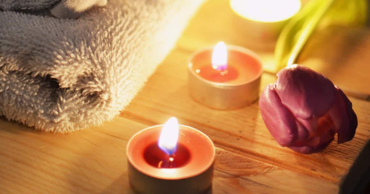 best ways to relax after a stressful day - image of towel, tealights, and a rose