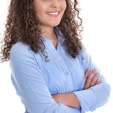 professional young woman with a blue button-front blouse on and curly hair