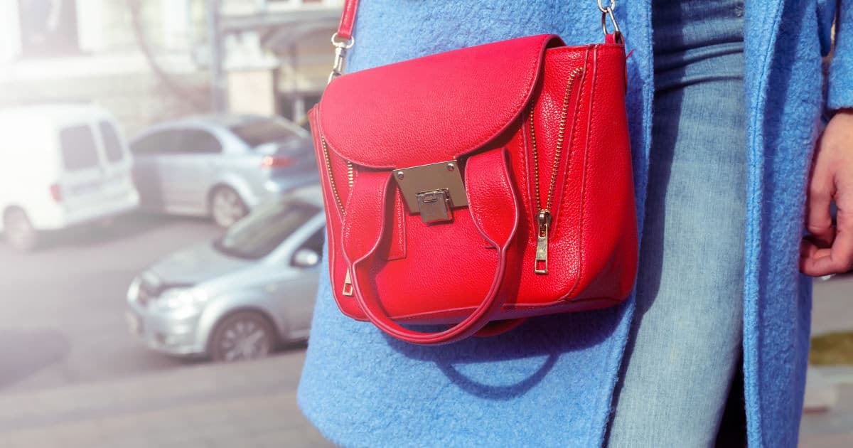 woman with blue coat wears a red handbag that looks like a 3.1 Philip Lim