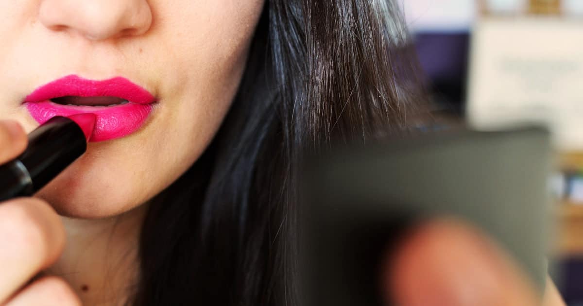 how much makeup do you wear for work - image of a woman applying lipstick