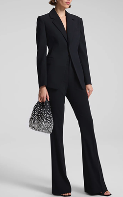 woman wears black suit with chic bag