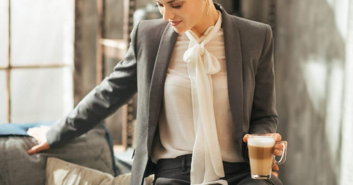 stylish tops for under women's suits - stock photo of a young woman wearing a bow blouse under a suit