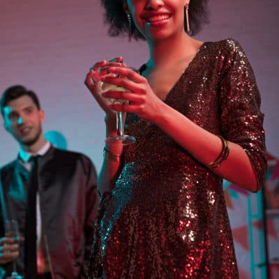 woman wears sequin dress and has a drink in her hands -- is it wedding wear or work wear?