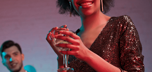 woman wears sequin dress and has a drink in her hands -- is it wedding wear or work wear? 