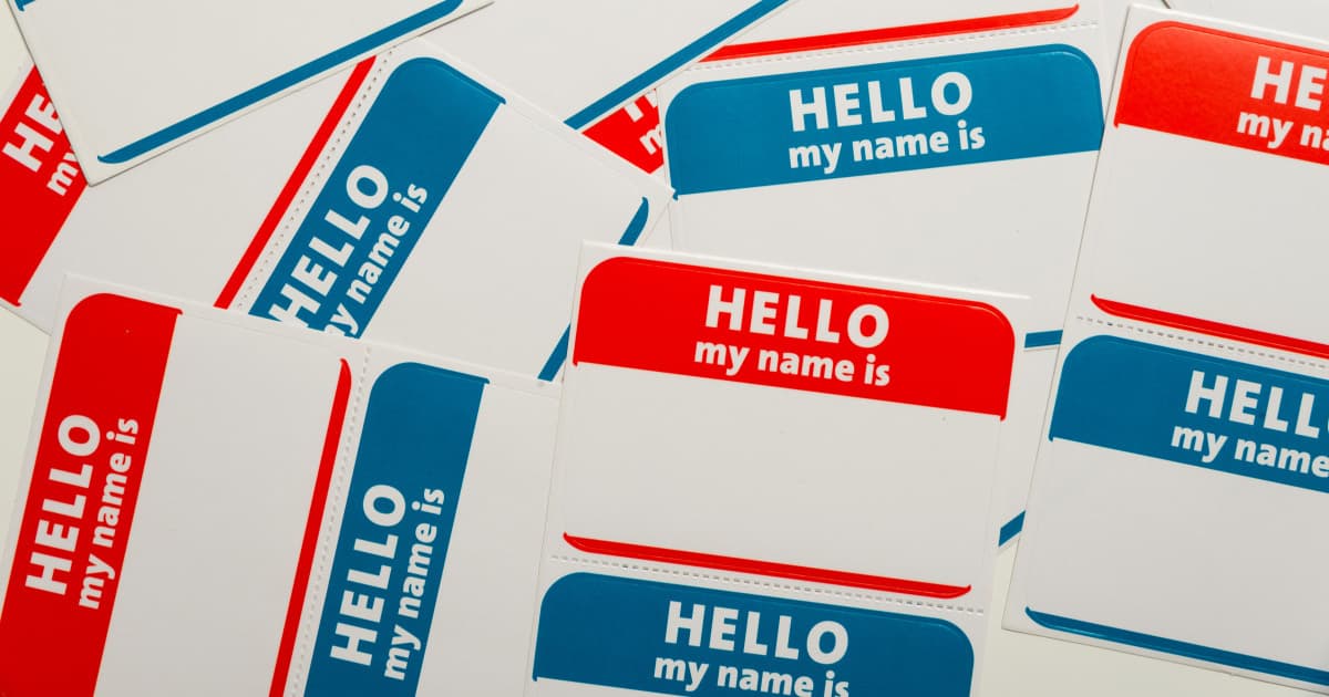 a number of name tag stickers that say "Hello My Name Is" are in a messy pile