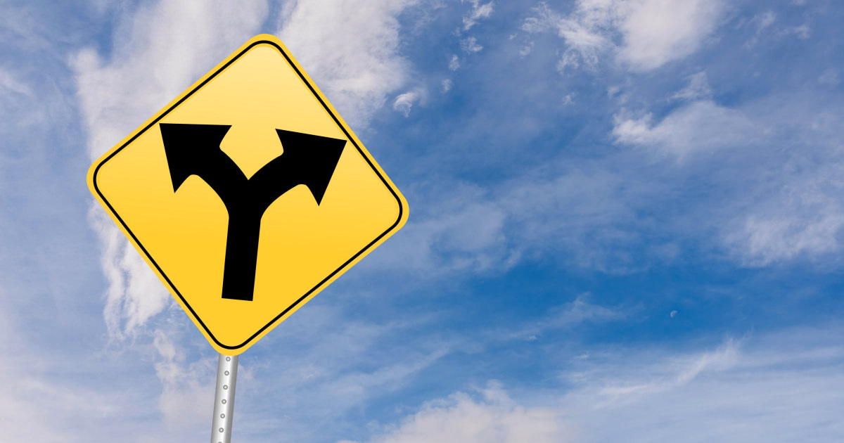 stock photo of yellow traffic sign showing one path with two arrows forking out
