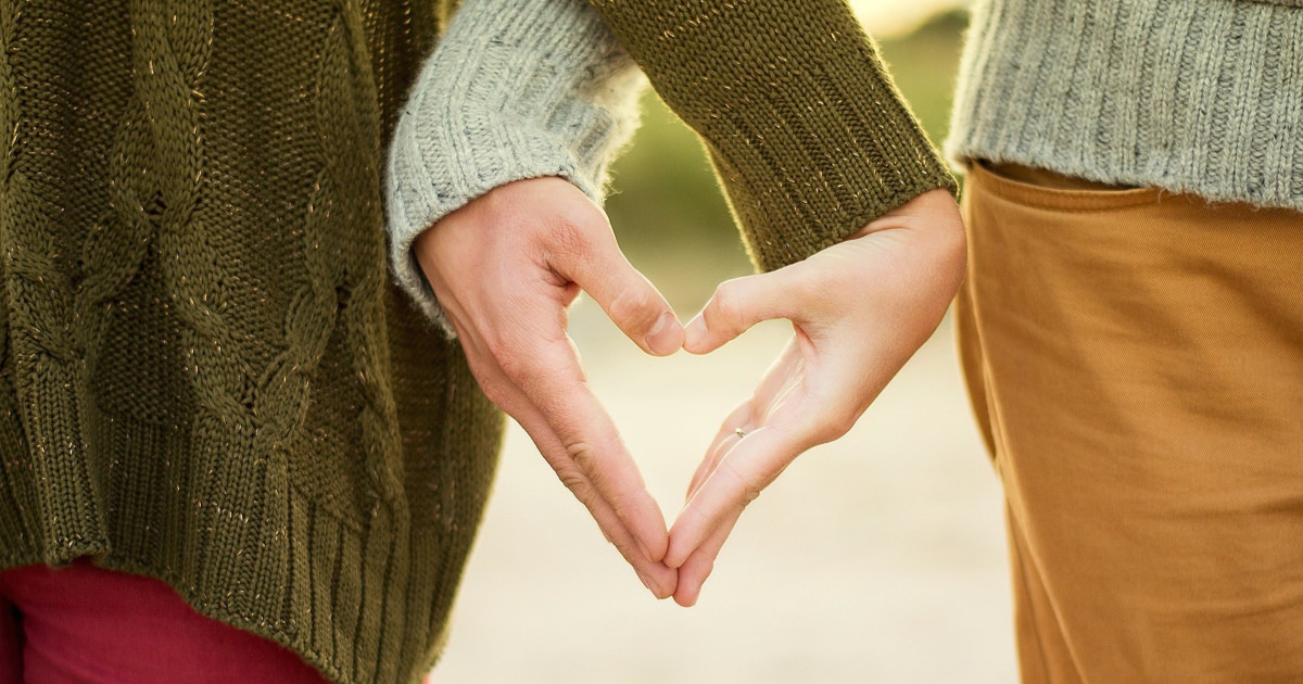 stock photo of couple making a heart shape with their hands