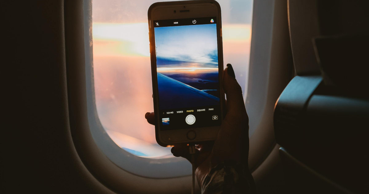 stock photo of woman taking picture out plane window
