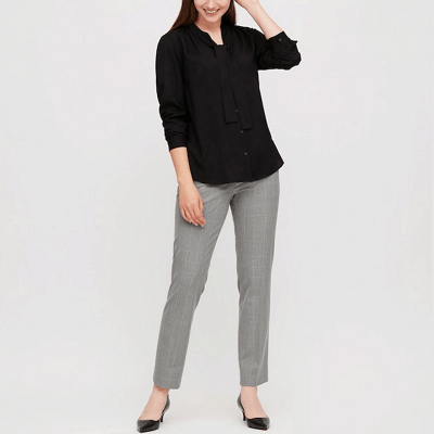 woman wears gray pants with black top and black shoes