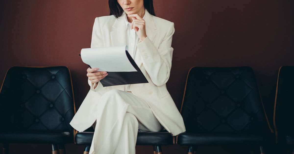stylish businesswoman wonders if she chose the correct interview attire for this type of job
