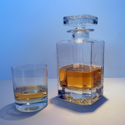 decanter and lowball glass featured against a blue background