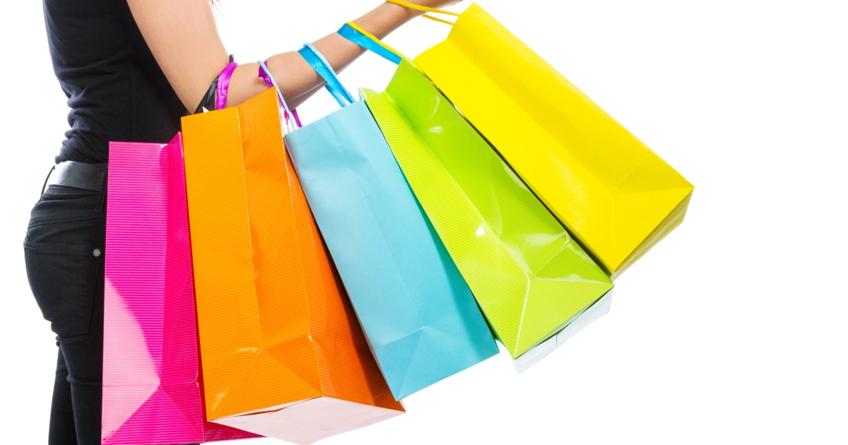businesswoman holding many multi-colored shopping bags