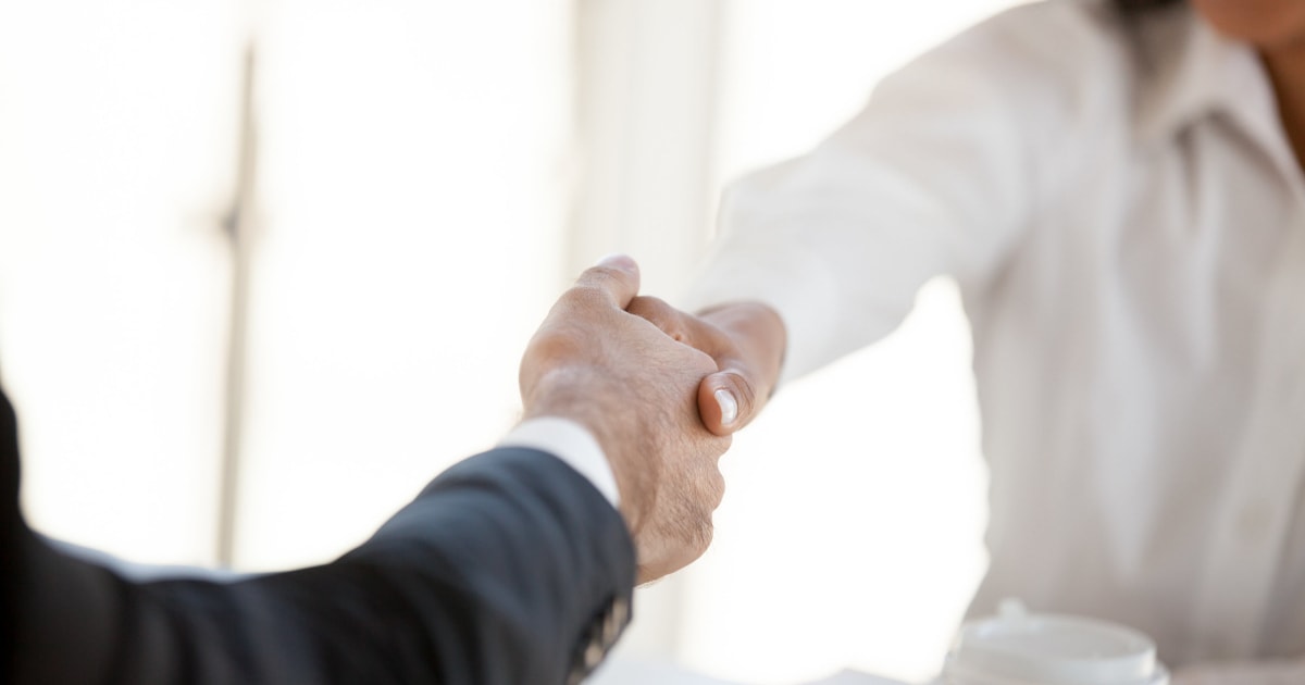 businesswoman and man in suit shaking hands