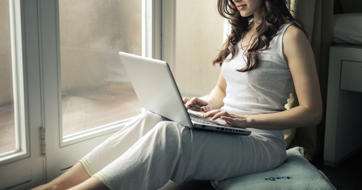young woman in pajamas on laptop