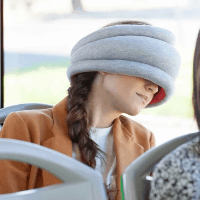 weird travel nap pillow that covers your eyes and acts as a pillow against the window of the bus