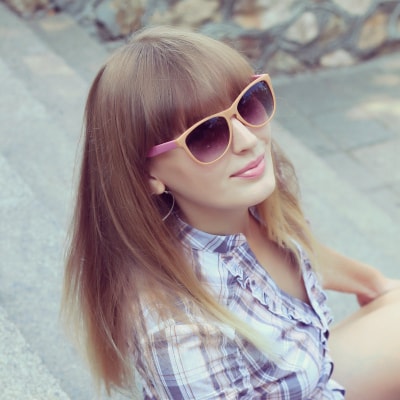 woman has thick bangs and wears sunglasses