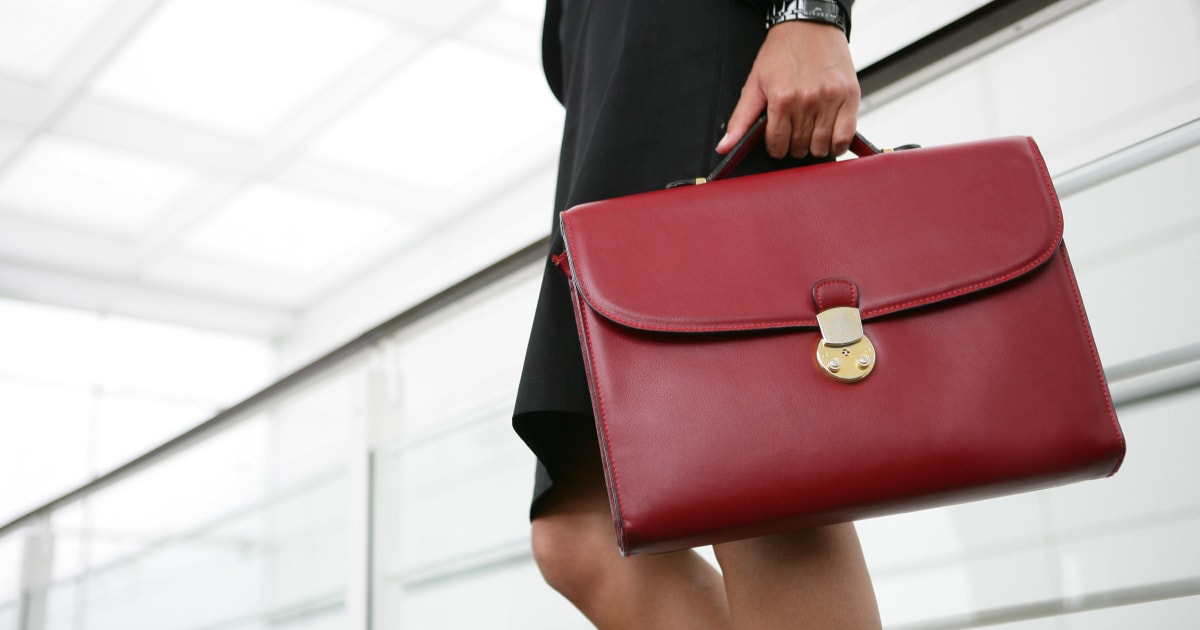 young professional woman headed back to the office with a skirt suit and briefcase
