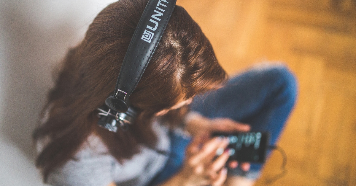 young professional woman listening to headphones