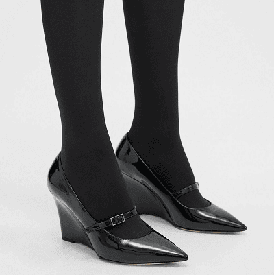 black patent leather Mary Jane wedge heels, worn with black tights