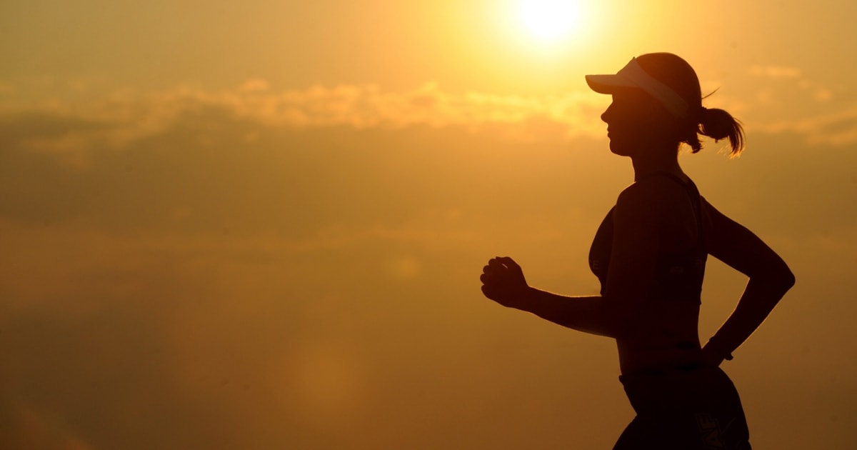 woman jogging with sunrise in background