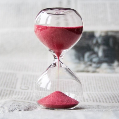 red sand falling through hourglass timer