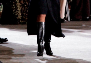 Condoleeza Rice wearing black leather boots, bare legs, a black pencil skirt and a black overcoat
