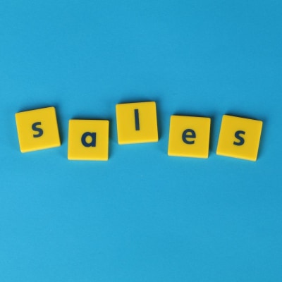 yellow blocks spell the word SALES; they sit on a blue background