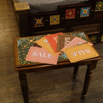 colorful envelops on table all read SALE