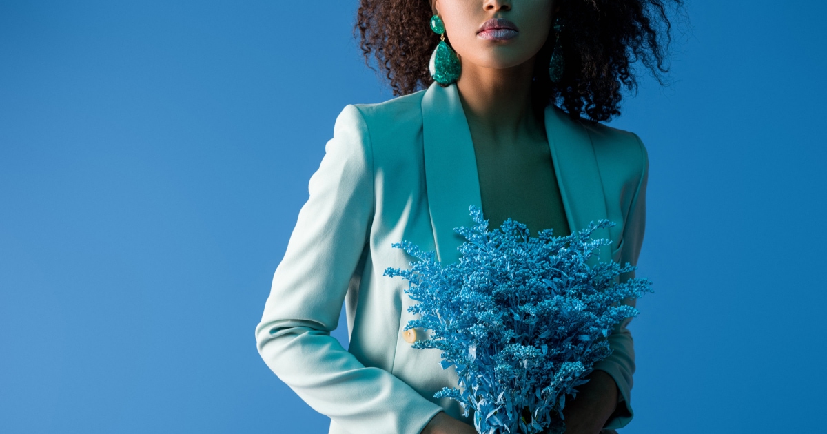 professional young woman wearing a blue suit and holding a blue bouquet