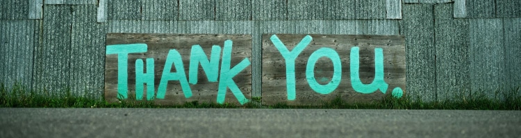 graffiti on wall reads THANK YOU! in minty green letters