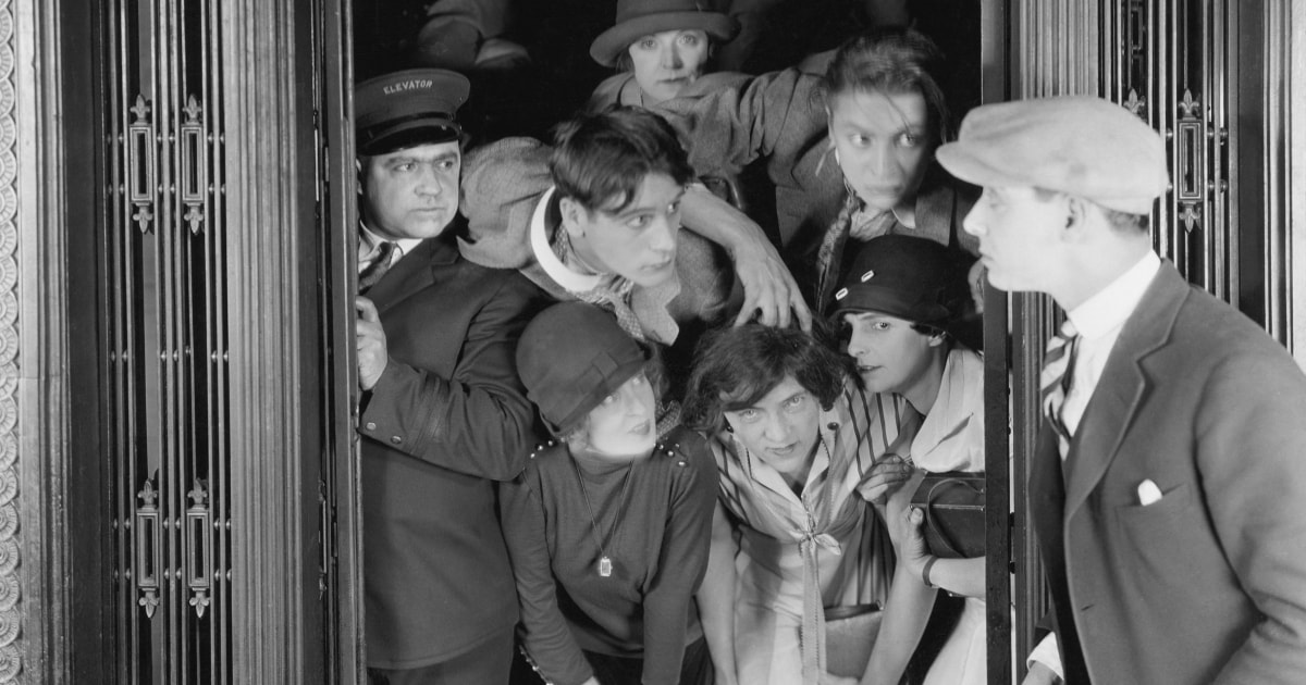comically crowded elevator filled with people in clothes from the 1930s